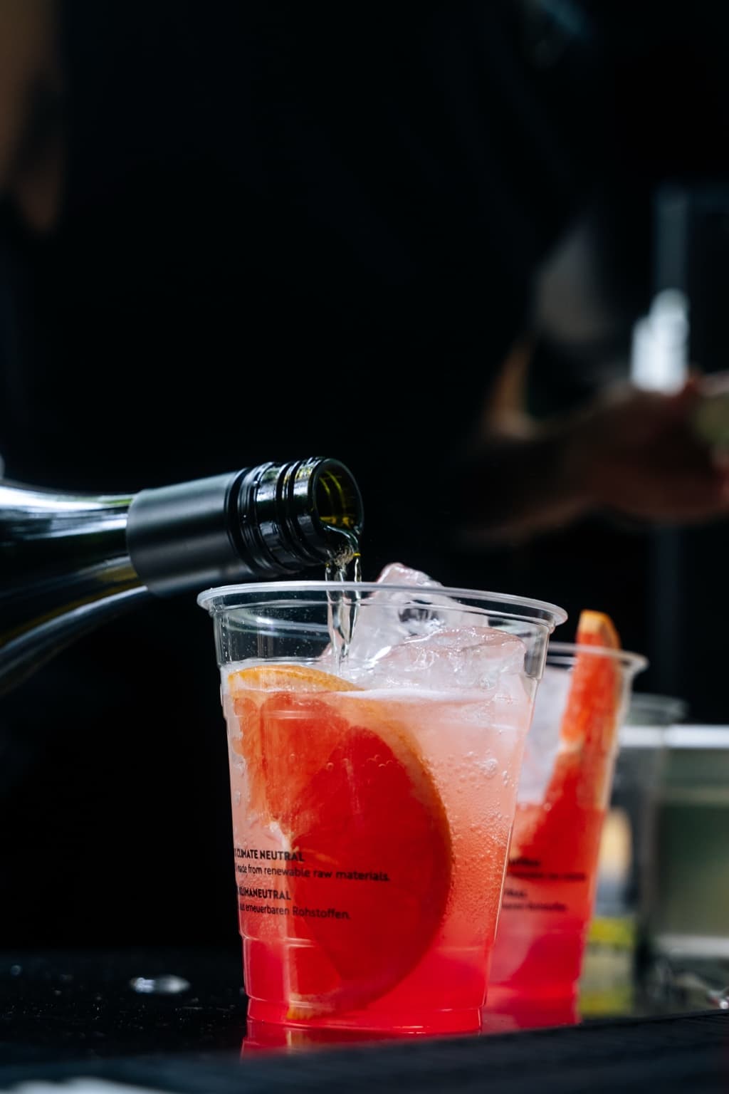Ein Drink mit Eis und einer Zitrusscheibe wird an der Bar aufgegossen